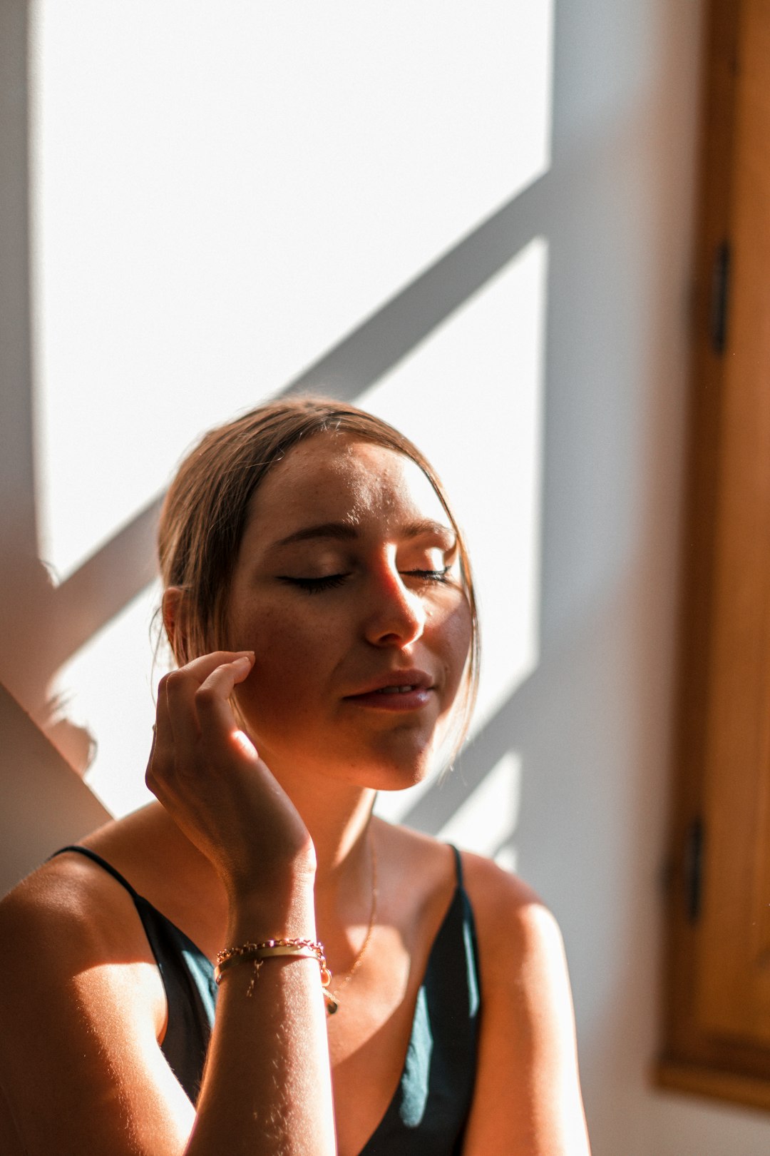 Woman in sunlight touching her skin
